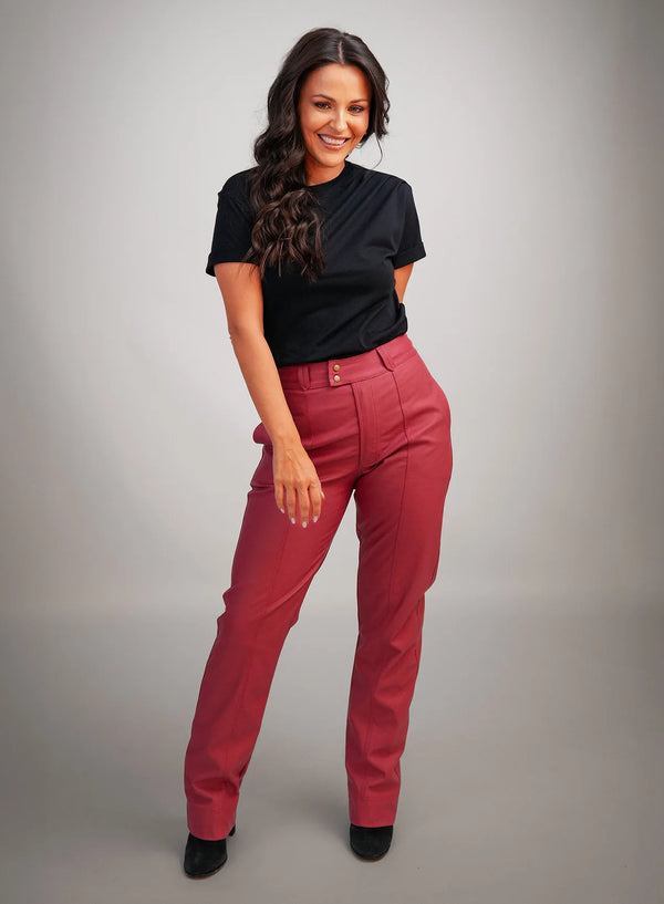 Modelo vestindo calça vermelha, blusa preta básica e sapato de salto alto preto.