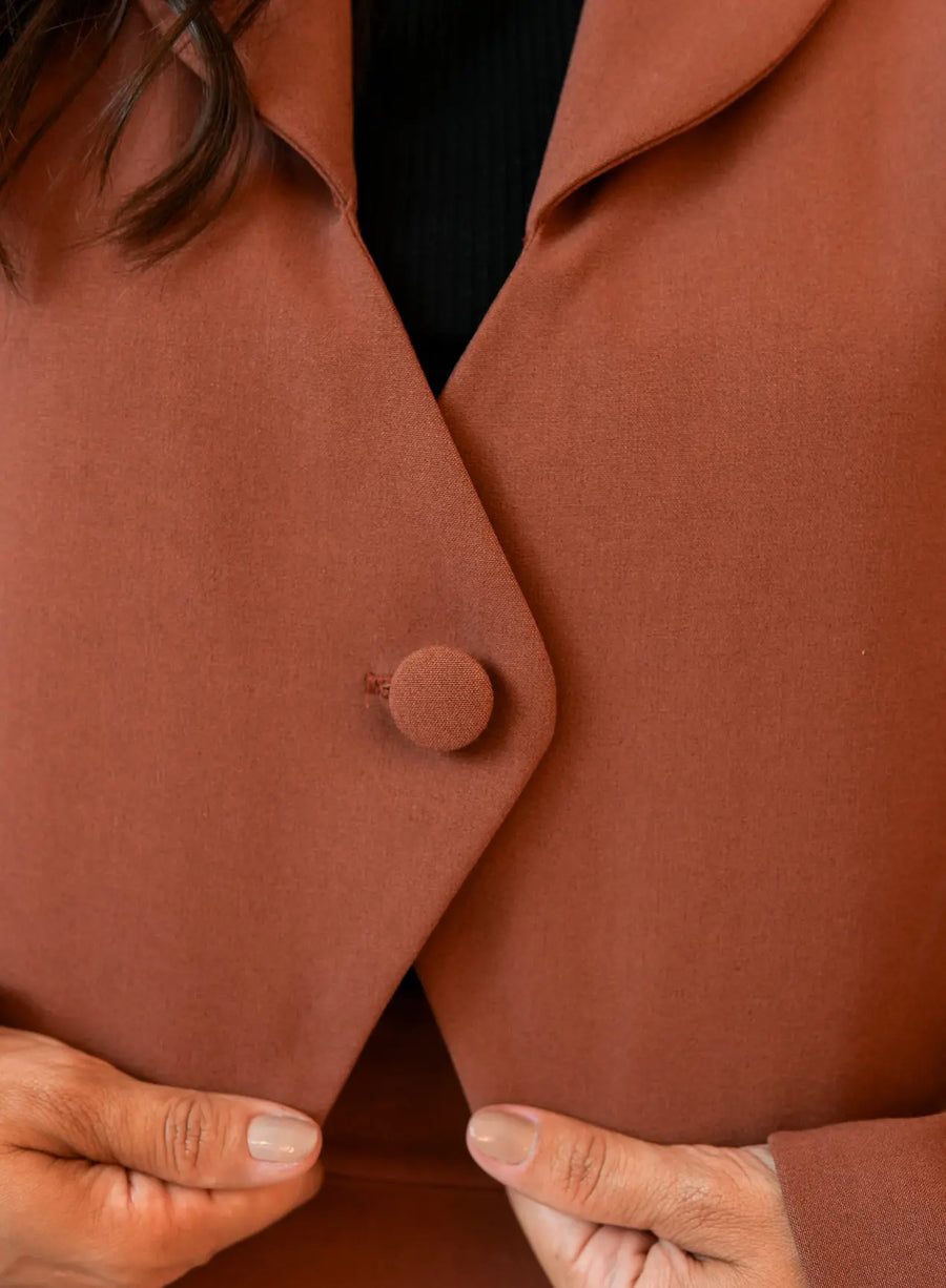 Detalhe do botão único do blazer marrom da Elaz.