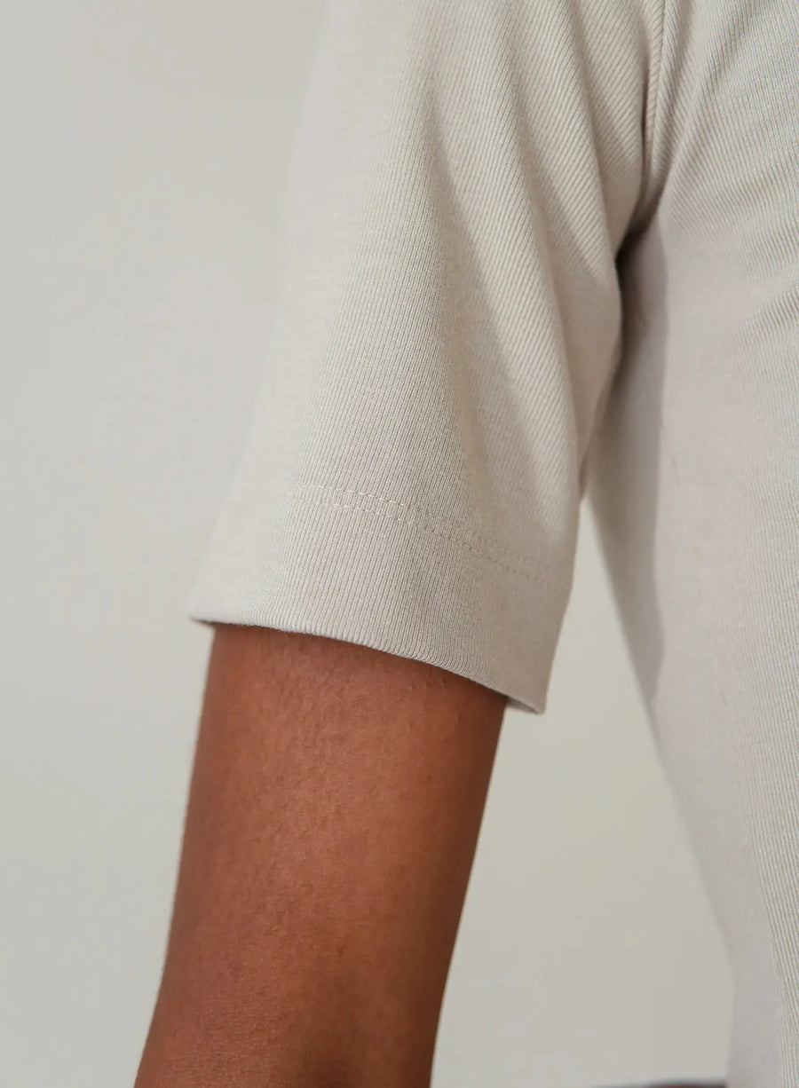 Close da manga da blusa tshirt bege.
