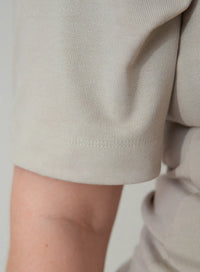 Imagem detalhada do tecido canelado da manga da blusa tshirt bege.