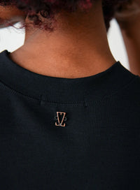 Detalhe da parte de trás da blusa tshirt preta com pequeno pingente dourado da logo da Elaz.