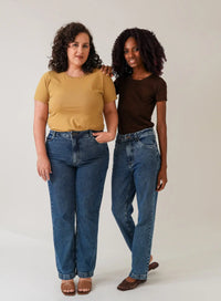 Modelos lado a lado posando com calça jeans azul e blusas básicas nas cores amarelo e marrom.