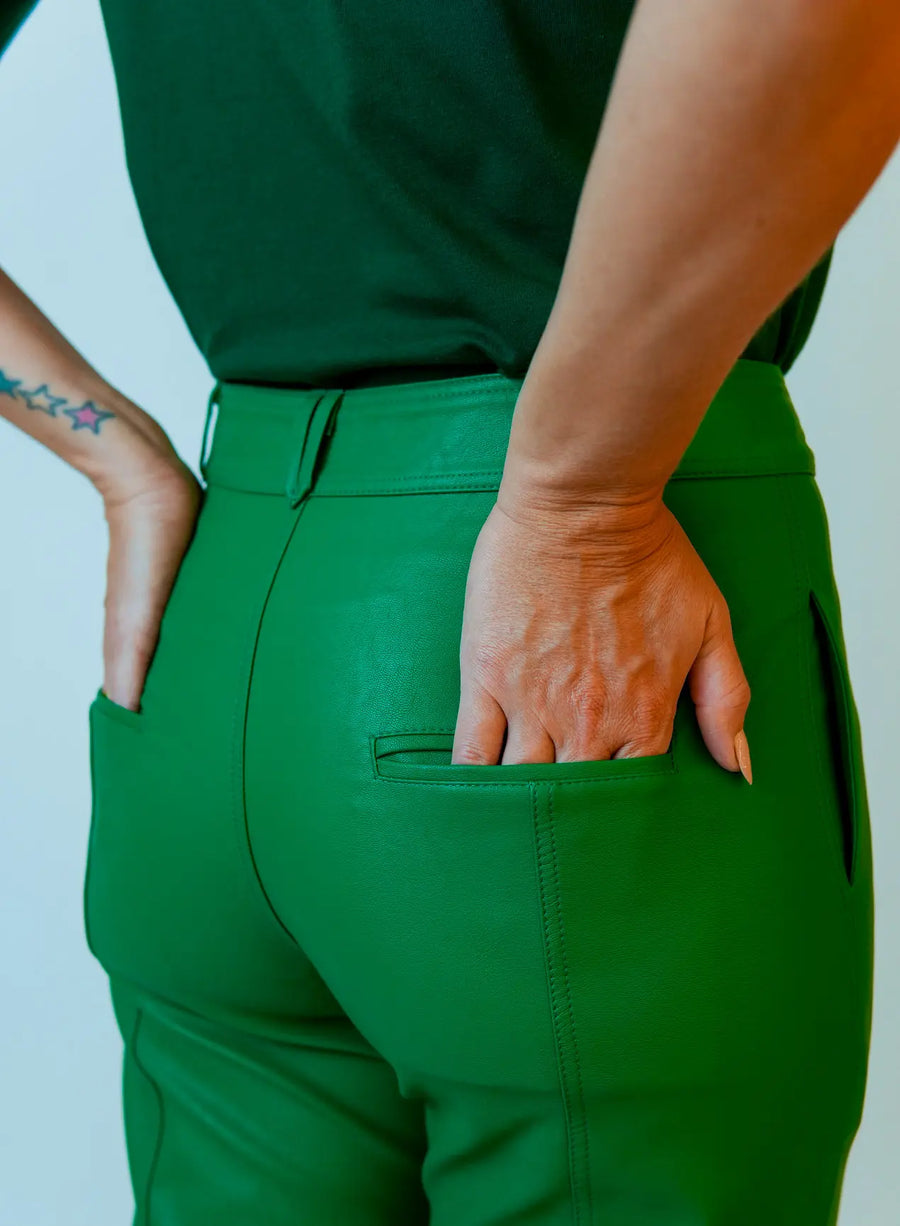 Parte de trás da calça em viscose verde com bolsos traseiros.