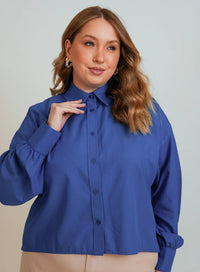 Modelo posando em fundo neutro vestindo camisa azul feminina da Elaz.