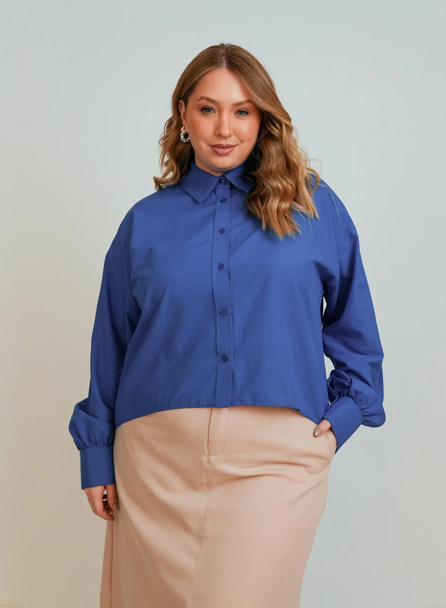 Modelo vestindo camisa azul feminina com botões da Elaz.