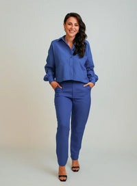 Modelo vestindo conjunto composto por camisa feminina azul e calça também azul.