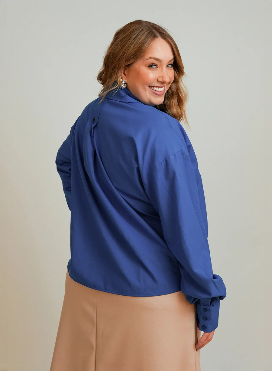 Modelo vestindo camisa azul feminina e saia bege Lais.