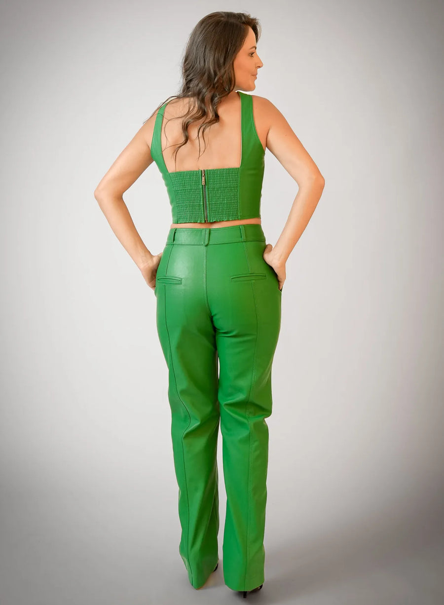 Modelo de costas vestindo cropped verde, calça em viscose e salto.