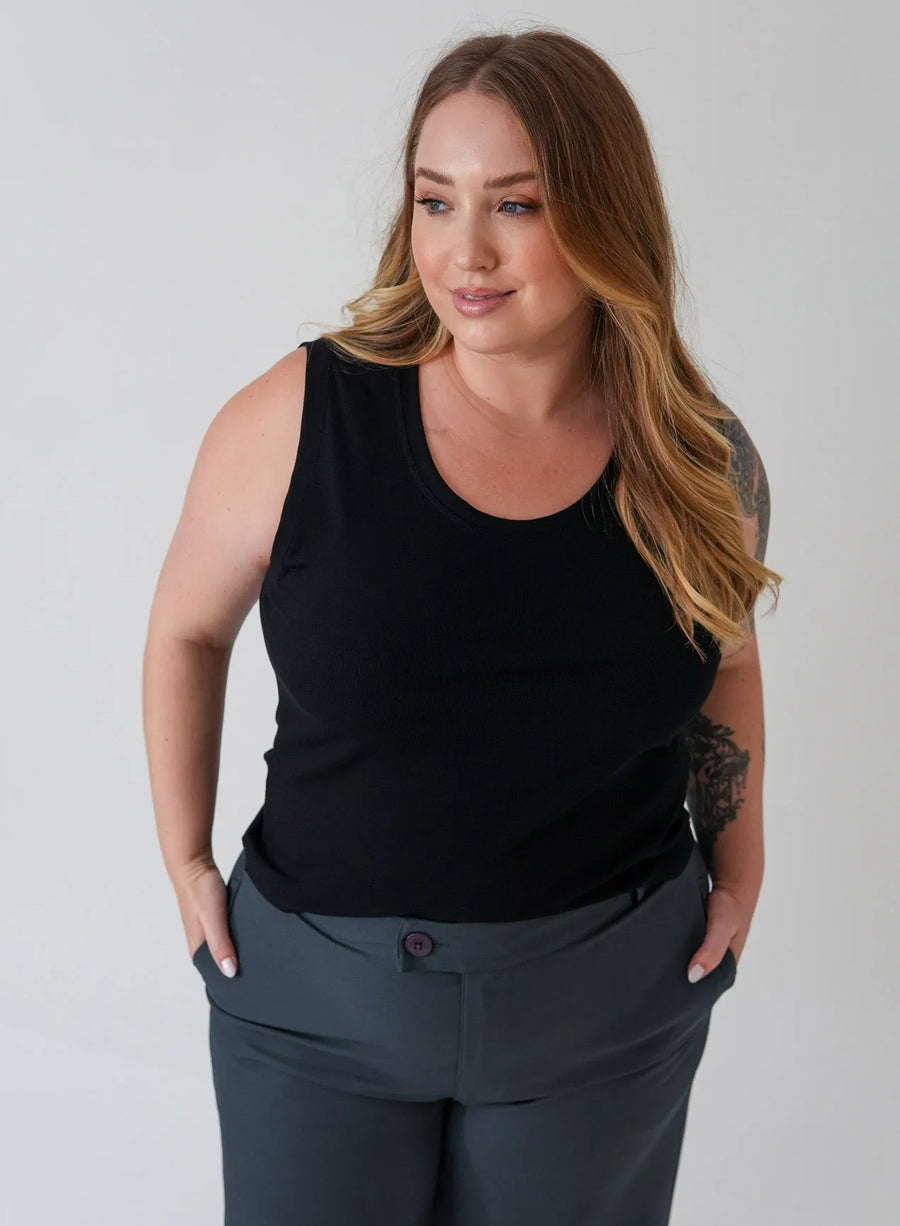 Modelo vestindo regata preta e calça alfaiataria cinza chumbo.